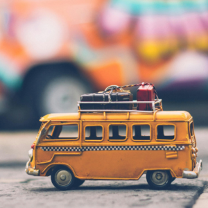 A toy bus with luggage on top of it.