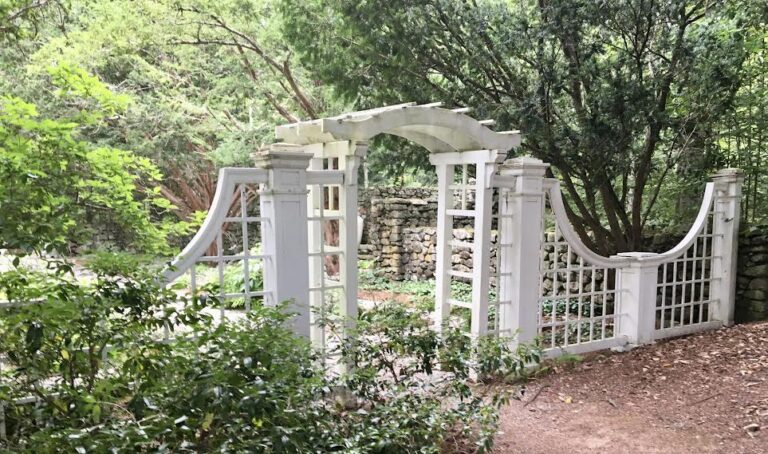 Intricate fence and arch leading to the old garden