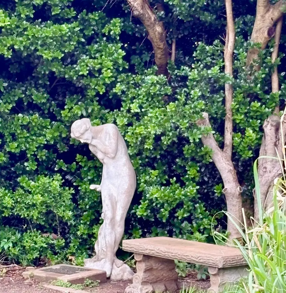 Statue of a woman and bench at Will Rogers Garden